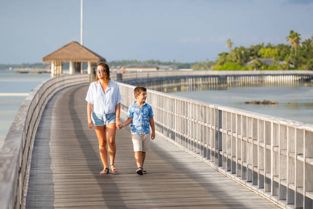 istock Mother and son on a runway holding hands 1370690229
