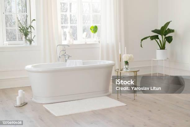White Modern Bathroom With Silver Fittings With Large Sunny Windows Decorations And Plants Interior Design Concept Soft Selective Focus Stock Photo - Download Image Now