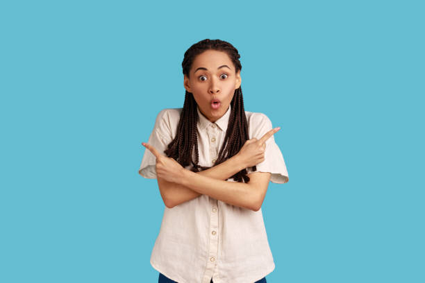 istock Woman points fingers in different sides, demonstrates two directions, shows something left and right 1370690615