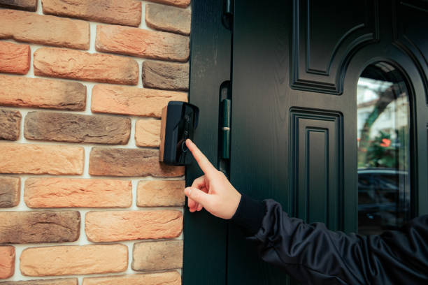 man hand in a black jacket rings the door intercom - chamada de fotografia imagens e fotografias de stock