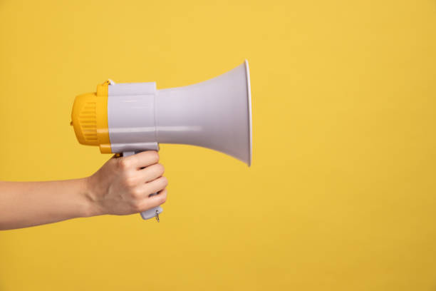 Profile side view closeup of woman hand holding megaphone, announcing of advertisement. stock photo