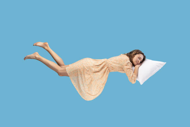 istock woman levitating in mid-air, sleeping on stomach lying comfortable cozy on pillow 1370691776