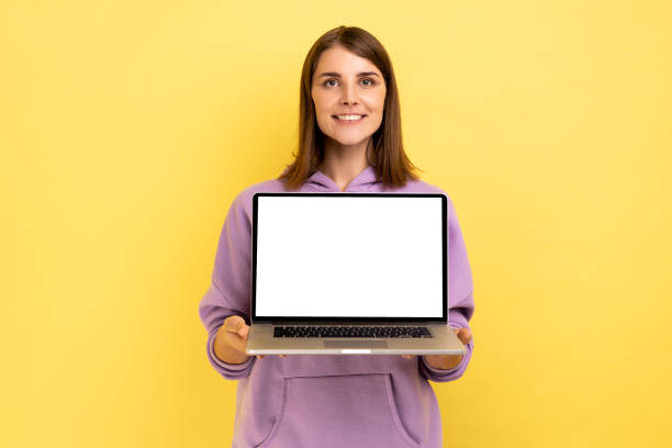 istock Positive optimistic woman standing showing laptop with white empty screen for promotion. 1370691946