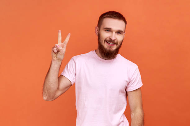 istock Man standing with raised hand and showing v sign or peace, victory gesture. 1370692159