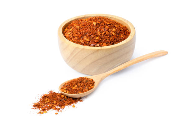 Dry red chili pepper powder (chilli)  on white Dry red chili pepper powder (chilli) in wooden bowl and spoon isolated on white background. cayenne powder stock pictures, royalty-free photos & images