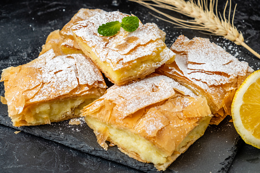 Bugatsa pastries made from filo puff pastry and custard sprinkled with powder.