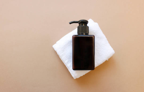 istock brown bottles with dispenser pumps on white towel. Copy space background. banner mockup. 1370694736