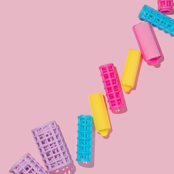 Hair rollers or curlers creative concept on pastel pink background. Colorful layout. Fun idea for hairstyling.