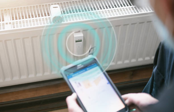 heating system engineer ist adjusting the digital w-lan network thermometer reader on a new thermal radiator. stock photo