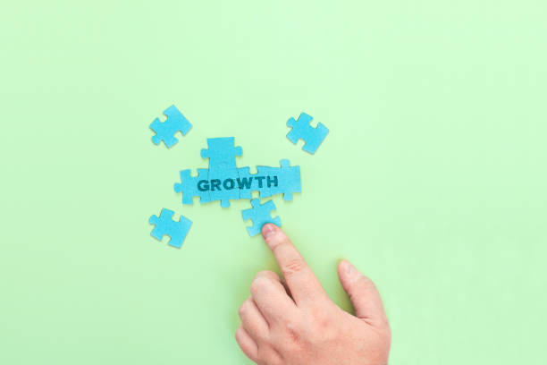 istock Businessman connecting puzzle pieces with the word Growth 1370695212