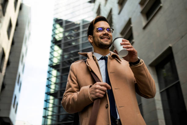 istock Smiling businessman on a way to work drinking coffee 1370695537