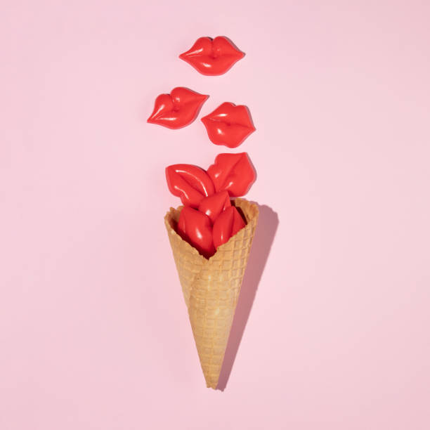 istock Ice cream cone with bright red lips figurines on pastel pink background. Minimal summer creative concept. Creative food idea. Flat lay. 1370696647