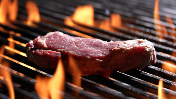 istock Grilling raw steak meat beef on flaming grill 1370697044