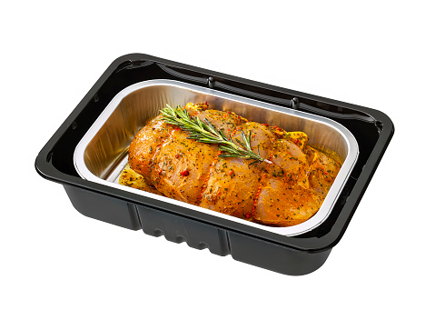 turkey roulade in black plastic tray isolated on white with clipping path