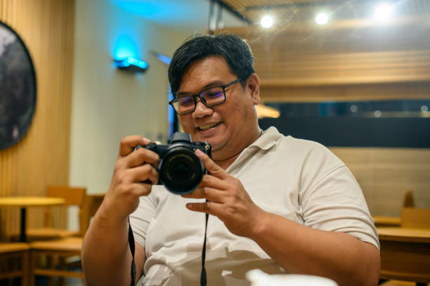 Asian man happily checking on camera results