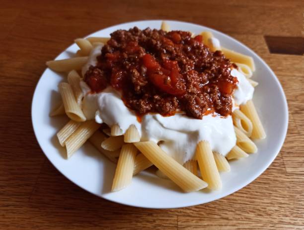 penne makkaroni gericht mit bolonesersauce und joghurt in glasgow schottland england uk - penne rigatoni pasta tomato pasta stock-fotos und bilder