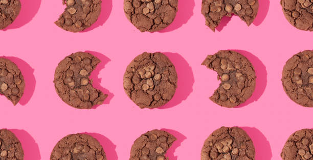 istock Creative pattern or frame made with chocolate chip cookies on bright bold pink background. Happy sweet fun life idea. Trendy food or dessert concept. Spring or summer layout. 80s or 90s retro fashion style. 1370700291