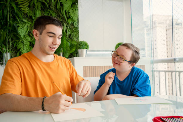 istock Boy with down syndrome and his brother drawing at home 1370700806