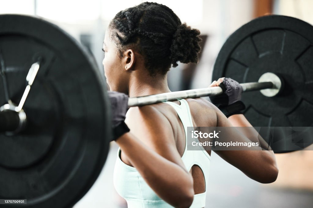 Shot of an unrecognisable woman using a barbell during her workout in the gym Resistance training will get you the body you want Weightlifting Stock Photo