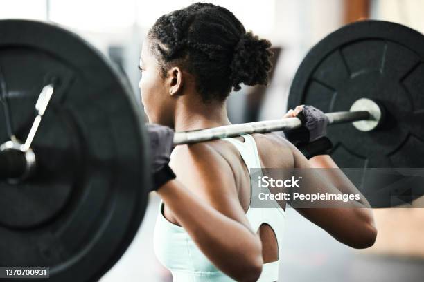 Shot Of An Unrecognisable Woman Using A Barbell During Her Workout In The Gym Stock Photo - Download Image Now