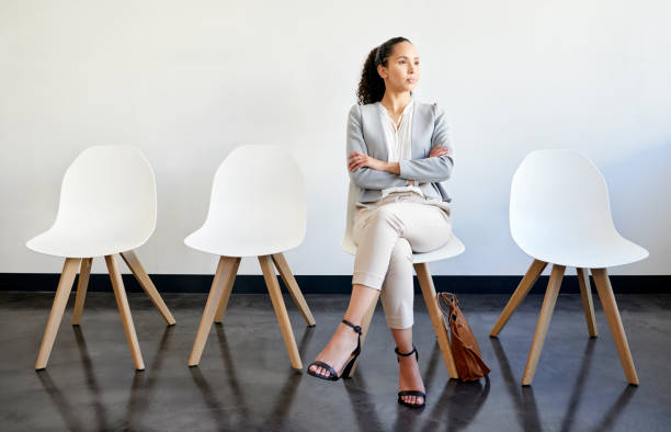 foto de una joven empresaria esperando en la fila de una oficina - con las piernas cruzadas fotografías e imágenes de stock