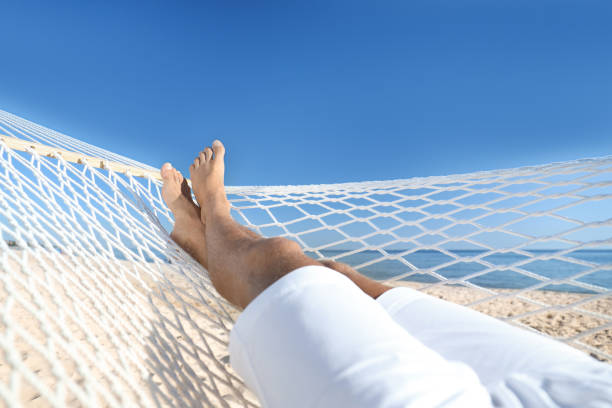 Man relaxing in hammock on beach, closeup