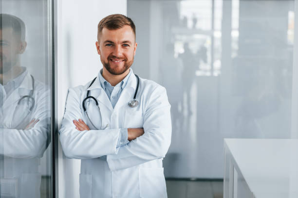 istock Front view. Professional medic in white coat is in the clinic 1370701878