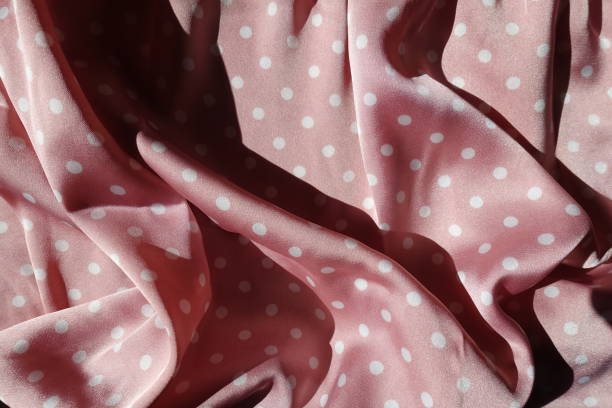 istock Rumpled satin fabric with pink and white polka dot pattern 1370704362