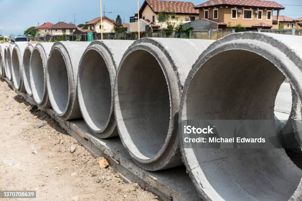 Large Precast Concrete Pipesegments Prepared On A Road For Sewage Storm Drain Or Water Supply Project Near A Residential Area Stock Photo - Download Image Now