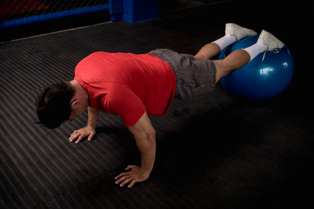 istock An athletic and fit asian man does pushups on a stability ball. Abdominal and core exercise and workout. Overhead shot. 1370709926