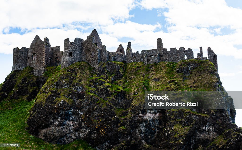 Ruin of the old Dunluce castle in Northern Ireland, United Kingdom nearby Bushmills. Remains of a medieval castel or historical fortress built with stones on top of a cliff in county Antrim. Ireland Irish Culture Stock Photo