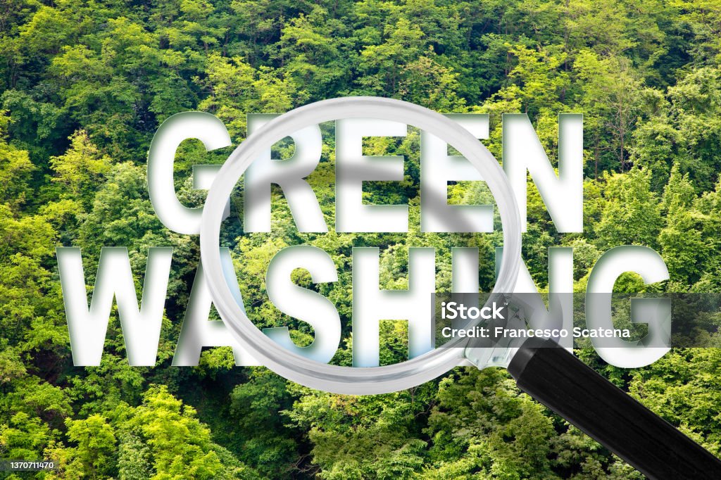 Alert to Greenwashing - concept with text against a forest and trees and magnifying glass Greenwashing Stock Photo