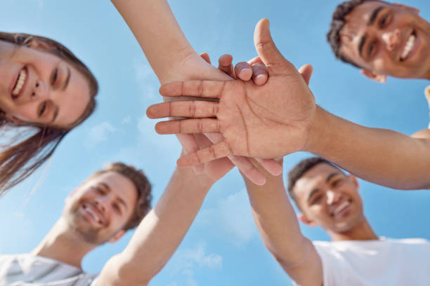 istock Low angle shot of a group of young people stacking their hands 1370712101