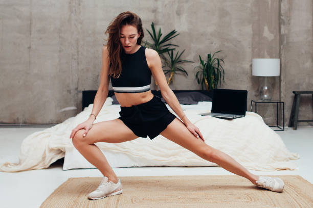 istock Woman practicing at home doing leg stretching exercises 1370713129