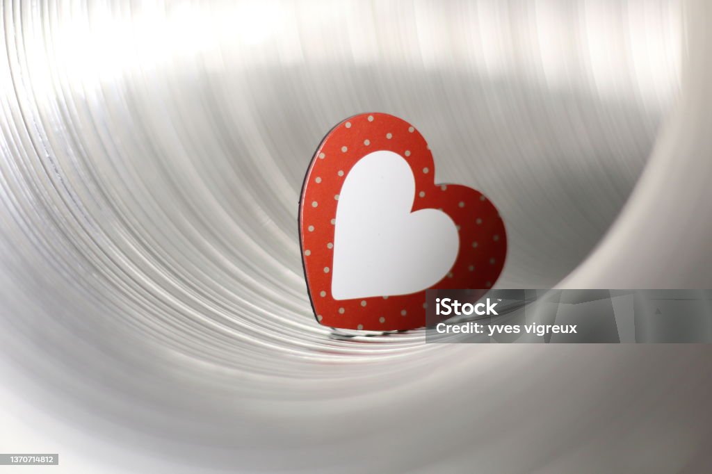 a red and white heart metal tube with a red and white heart inside Color Image Stock Photo