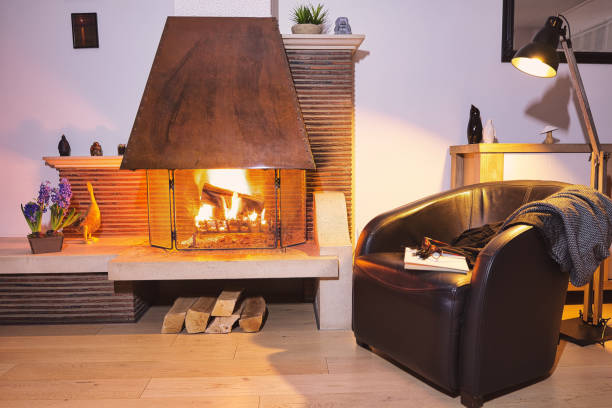 wood burning fireplace and armchair stock photo