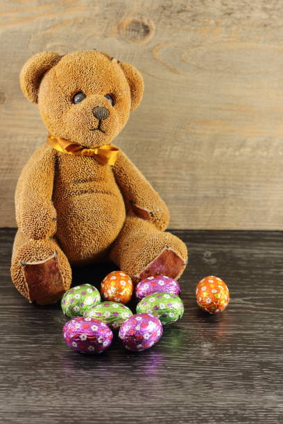 a teddy bear wih its easter eggs stock photo
