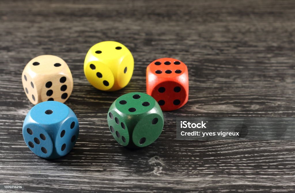 five dice played colorful games of five  colorful dice  on a black table Chance Stock Photo