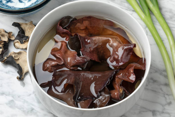 Dried jews ear mushrooms soaking in a bowl Dried jews ear mushrooms soaking in water in a bowl close up auriculariales photos stock pictures, royalty-free photos & images