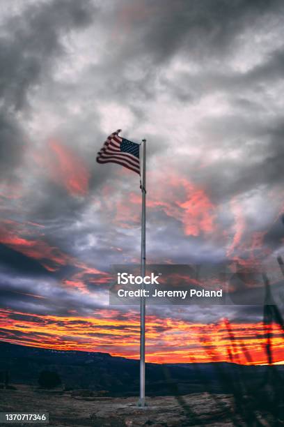 Low Angle Artistic Sunrise Shot Of An American Flag Pole On A Windy Stormy Day Stock Photo - Download Image Now