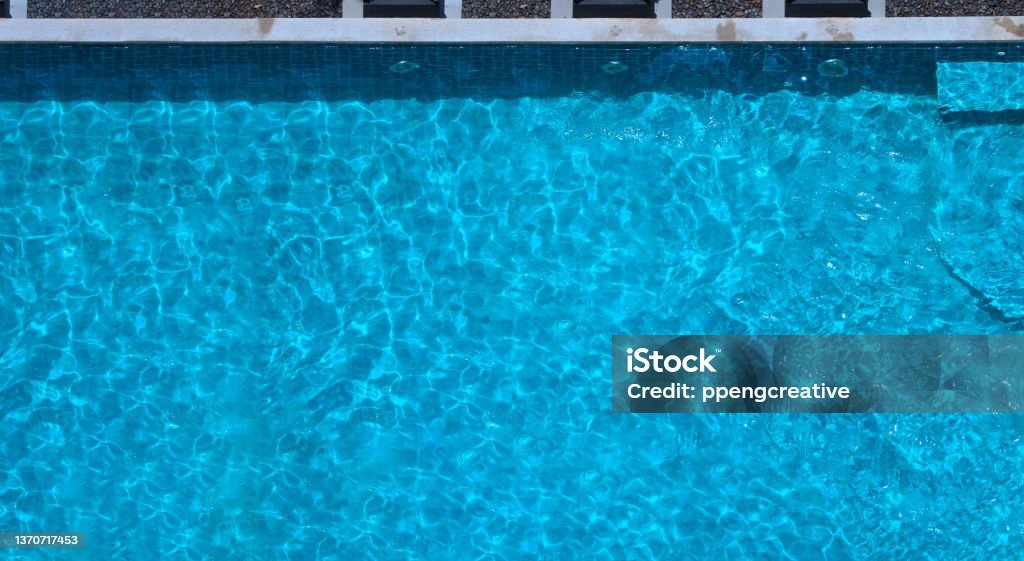 Swimming pool blue water in summer top view angle. Aerial view images of swimming pool in a sunny day which suitable for sport or relax on vacation time or workout for burn some calories in holiday. Above Stock Photo