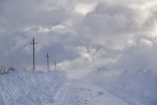 istock A deserted country road through snow-covered fields. 1370719934