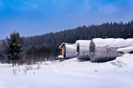 shift camp with cylindrical portable buildings in snowy winter northern taiga