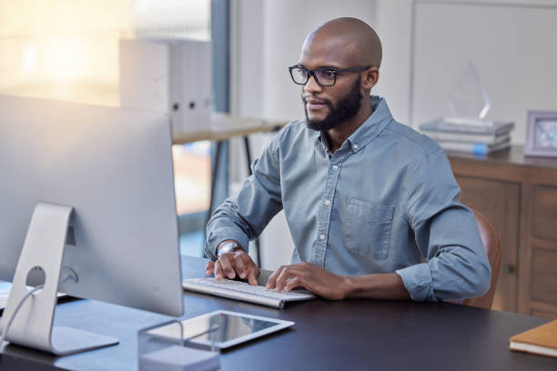 istock Shot of a young businessman using a computer in an office at work 1370723784