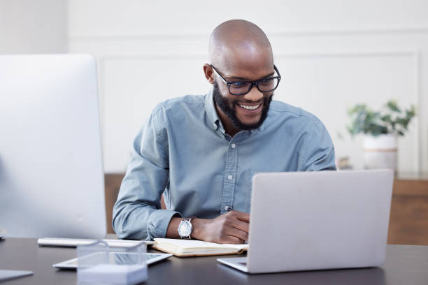 Shot of a young businessman using a laptop in an office at work