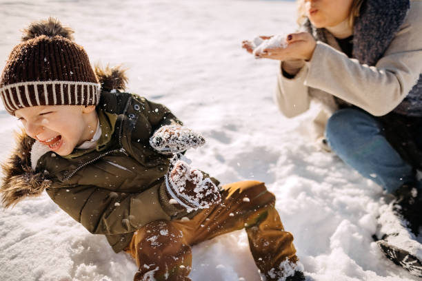 istock Mother and son playing in snow 1370726532