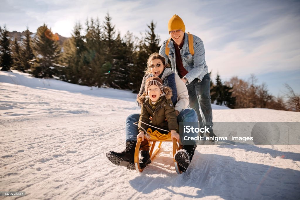 Winters Magics Family with one child enjoys a beautiful day in the snow Family Stock Photo