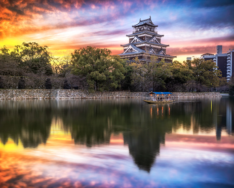 25 march 2019, Hiroshima - Japan: Hiroshima Castle with a boat with tourists in front in the morning