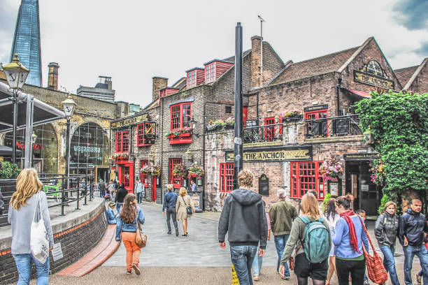 A group of tourists walk down a London street A group of tourists walk down a London street and enjoy their holiday. bankside photos stock pictures, royalty-free photos & images