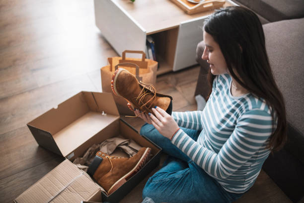 istock Young woman unwrapping package at home. 1370727041